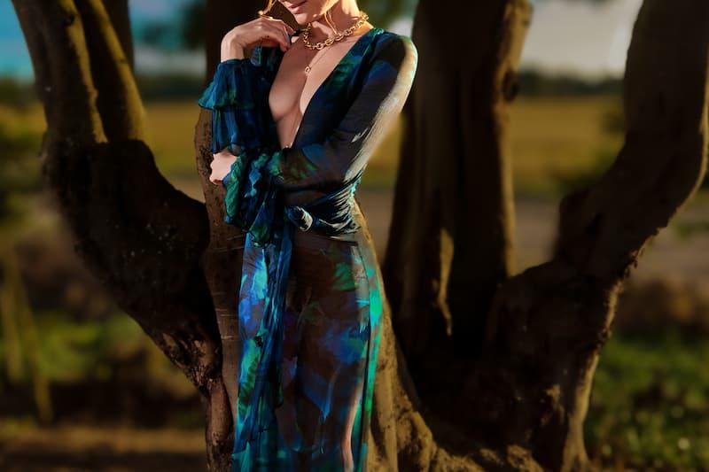 High-class escort in Ireland in a blue-green gown at dusk